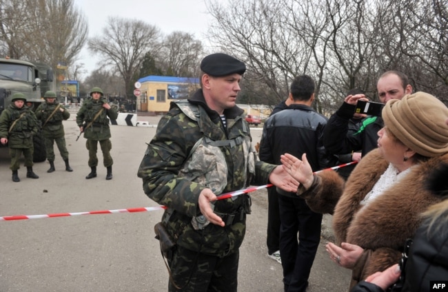Женщина разговаривает с украинским военным в Керчи, 4 марта 2014 года