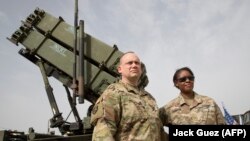 U.S. Army officers stand in front of a Patriot missile-defense system during a military exercise.