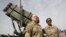 U.S. Army officers stand in front of a Patriot missile-defense system during a military exercise.