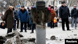 Люди розглядають залишки ракетного снаряду на вулиці Краматорська. 10 лютого 2015 року