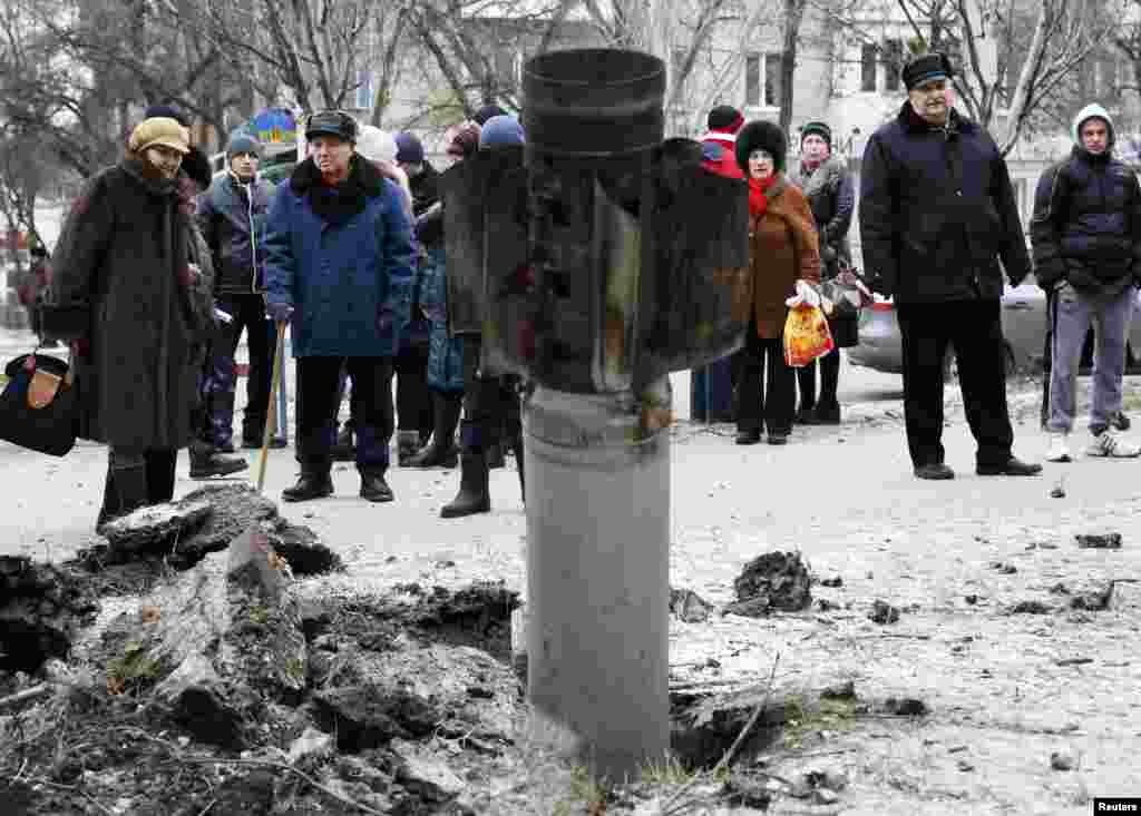 People look at the remains of a rocket shell on a street in the town of Kramatorsk, eastern Ukraine, on February 10. (Reuters/Gleb Garanich)