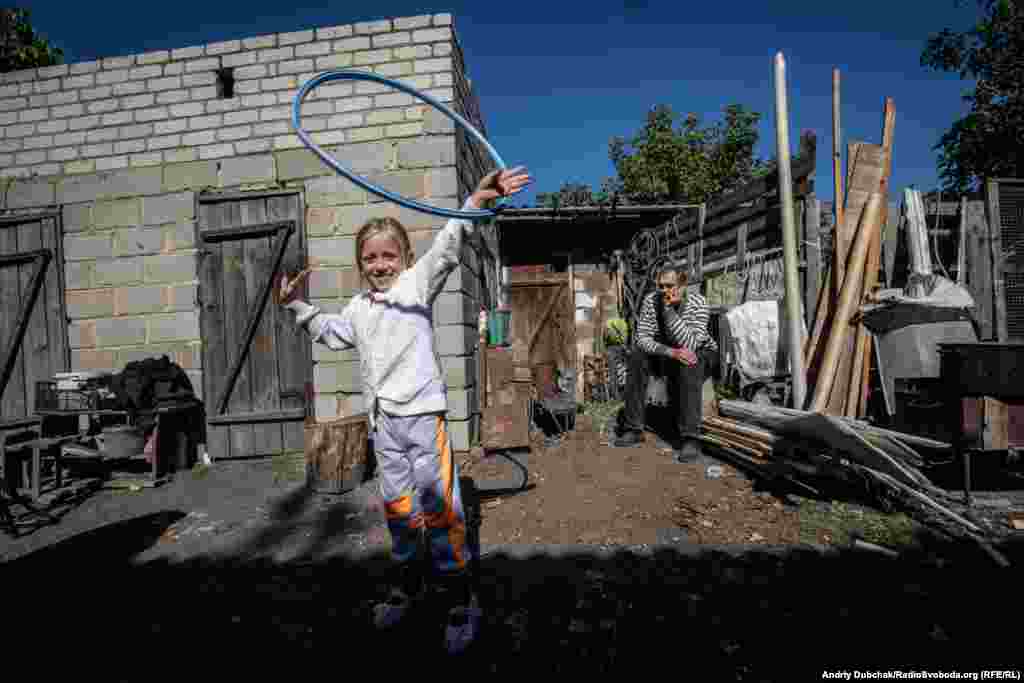 Toma plays in the yard of her house, just a few hundred meters away from frontline positions. In July 2017, when Russia-backed separatists fired mortars into the small Ukrainian town of Maryinka, Toma's stomach was hit by shrapnel from a shell that landed on the doorstep of her family's home. Find out more stories of the children living on Ukraine's front line in Ukraine's Frontline Children by photographer Andriy Dubchak of RFE/RL's Ukrainian Service. (Andriy Dubchak, RFE/RL)