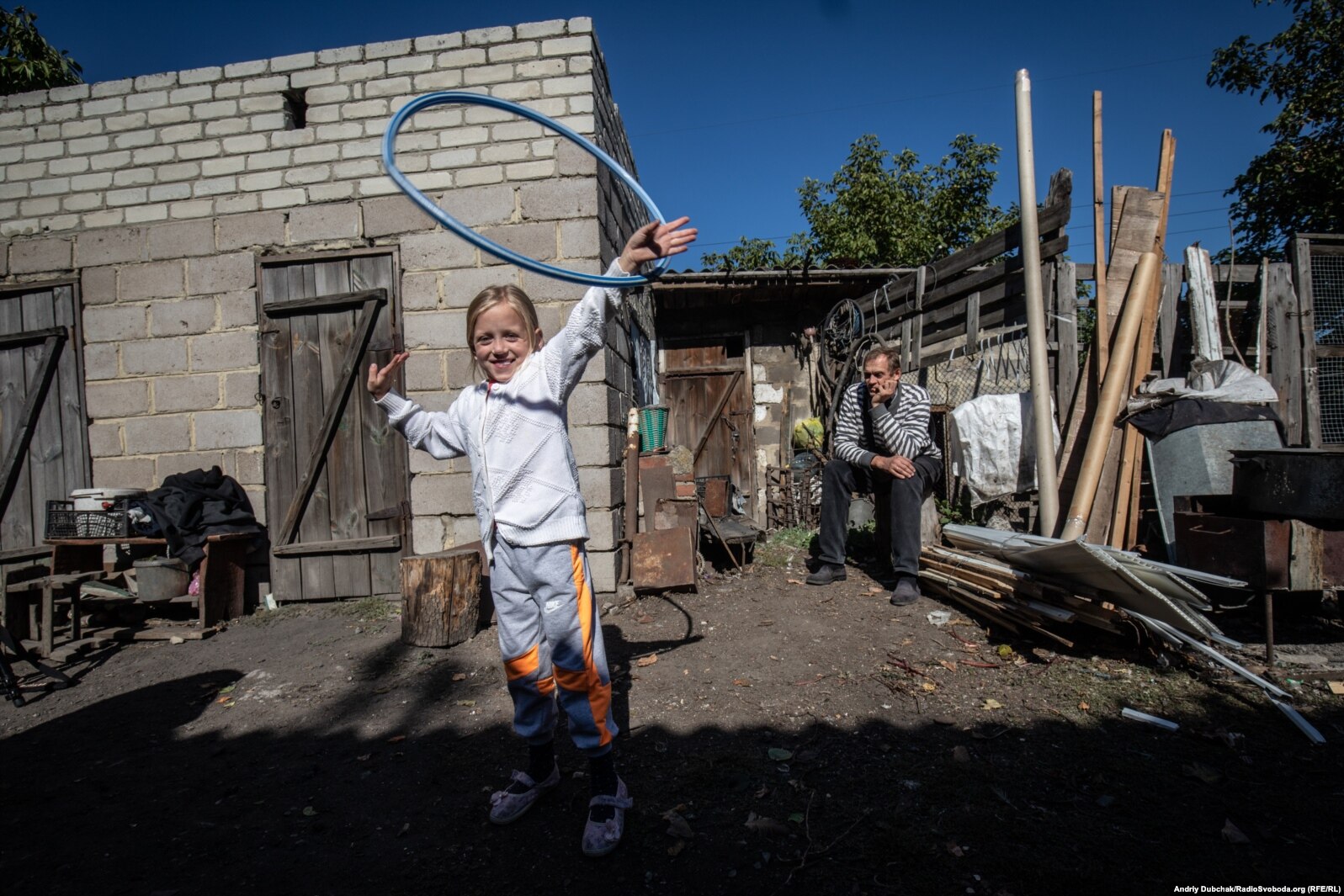 6-летняя Тома играет во дворе дома, откуда виден Донецк. В нескольких сотнях метров прошла линия фронта