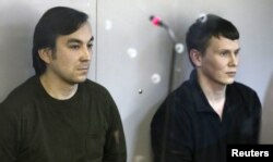 Yevgeny Yerofeyev (left) and Aleksandr Aleksandrov, Russian servicemen arrested last May on charges related to the separatist conflict in eastern Ukraine, look from a glass-walled cage during a court hearing in Kyiv earlier this month.