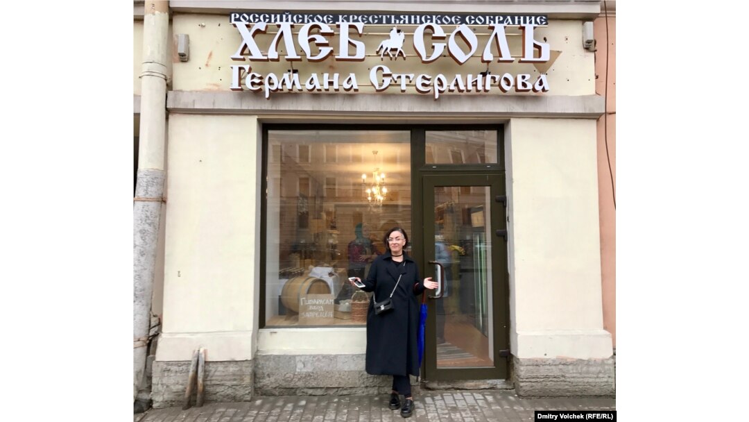Вера Врубель перед магазином "Хлеб Соль". В витрине – временная табличка