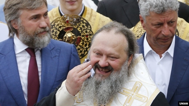 Настоятель Києво-Печерської лаври архієпископ УПЦ (МП) Павло (посередині) і народні депутати від «Опоблоку» Вадим Новинський (ліворуч) і Юрій Бойко (праворуч). Київ, 27 липня 2017 року