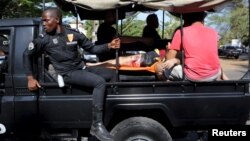 نیروهای امنیتی ساحل عاج در حال انتقال یکی از مجروحان حمله به ساحل گراند بسام در شرق پایتخت.