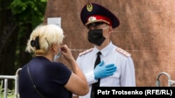 Сотрудник полиции и женщина, которая хотела попасть в Парк имени 28 гвардейцев-панфиловцев. Алматы, 9 мая 2020 года.