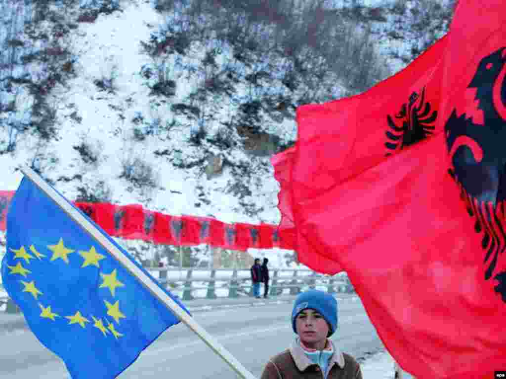 Në festë të pavarësisë - Caption: epa01257231 An ethnic Albanian boy holds an EU flag standing next to Albanian flags in the town of Kacanik, Kosovo, Serbia, 16 February 2008.