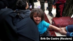 A girl cries next to other civilians who escaped from Islamic State militants at a mosque in Raqqa on October 12.