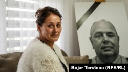 Fotografia e policit të vrarë më 2023 në veriun e Kosovës, Afrim Bunjaku, në prapavijë teksa bashkëshortja e tij, Lumnije Bunjaku, shikon në shtëpinë e saj në Samadrexhë të Vushtrrisë, 22 prill.