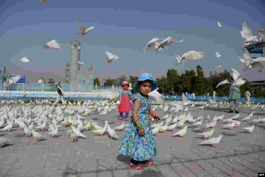 Afghan children, wearing new clothes, which is an Eid al-Fitr tradition, look on during the festival marking the end of the fasting month of Ramadan in Mazar-e Sharif on July 28. (AFP/Farshad Usyan)