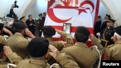 Турски кипарски ветерани салутираат пред ковчегот на поранешниот турски кипарски лидер Рауф Денкташ, покриен со турското и со знамето на кипарските Турци во северна Никозија на 16 јануари 2012 година.