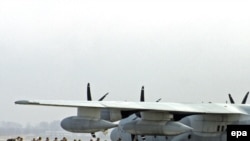 U.S. servicemen board a plane at Manas