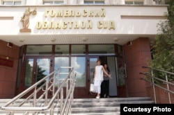 Лекарка Кацярына Шабетнік — у дзьвярах суду, перад ёй адвакатка ў белым.13 чэрвеня 2018 году