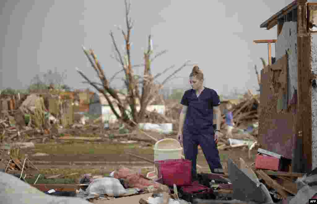 Dana Ulepich looks at the debris from her house.