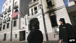 Serbian police look at a new flag raised at the U.S. Embassy in Belgrade in February 2008, which was set on fire by protesters enraged by Western support for Kosovo's independence.