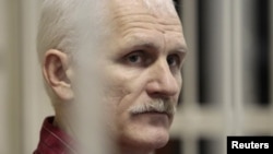 Belarusian human rights activist Ales Byalyatski sits in a guarded cage in a courtroom in Minsk during his trial in November 2011.