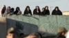 People watch an execution of a convicted man in the Iranian city of Qazvin in May
