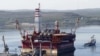 A floating oil platform is tugged from the harbor in the northern Russian port of Murmansk.