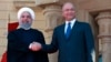 Iraqi President Barham Salih, right, shakes hands with visiting Iranian President Hassan Rouhani, at Salam Palace in Baghdad, Iraq, Monday, March 11, 2019. Iranian President Hassan Rouhani arrived in Baghdad on Monday, making his first official visit to 