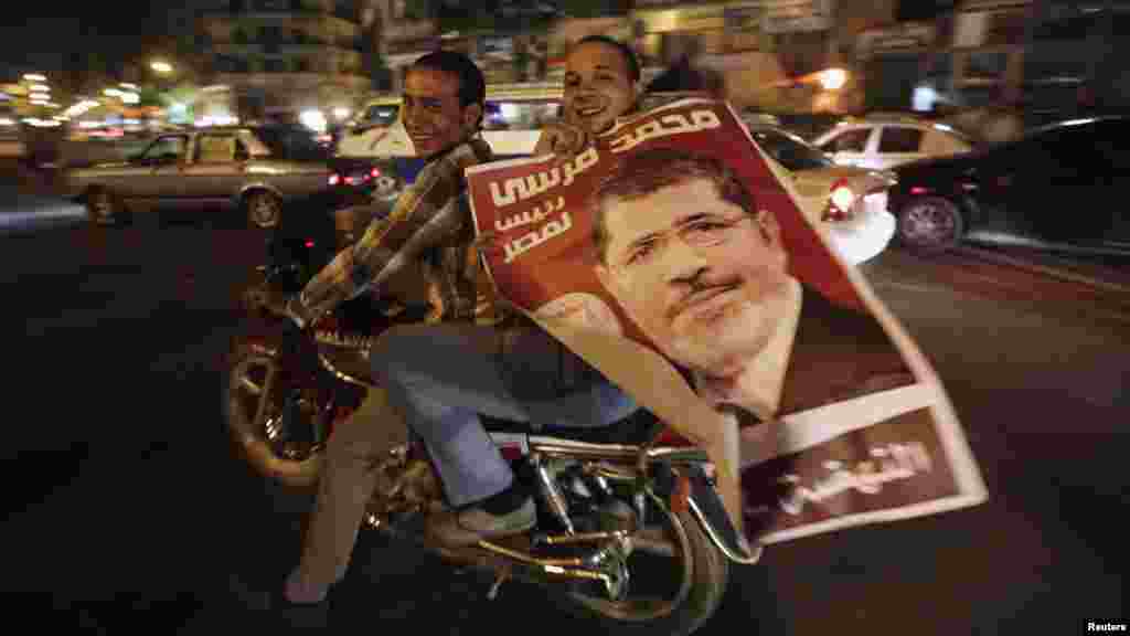 Supporters of newly elected Egyptian President Muhammad Morsi hold up his poster as they celebrate while riding a motorbike on Tahrir Square in Cairo on July 9. (REUTERS/Amr Abdallah Dalsh)