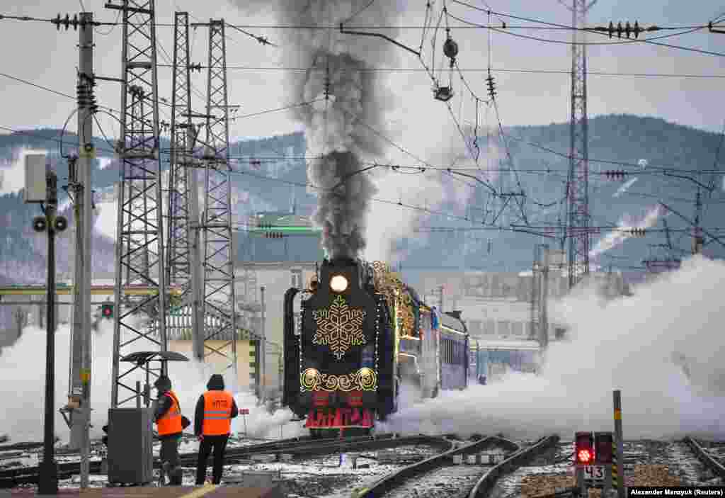 A steam train festooned with seasonal decorations moves along a railway in the Siberian city of Krasnoyarsk.&nbsp;