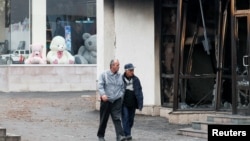 NAGORNO-KARABAKH -- Men walk past a burnt shop in Stepanakert, November 16, 2020