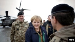 German Chancellor Angela Merkel is welcomed by officers of the German armed forces in Kundus.