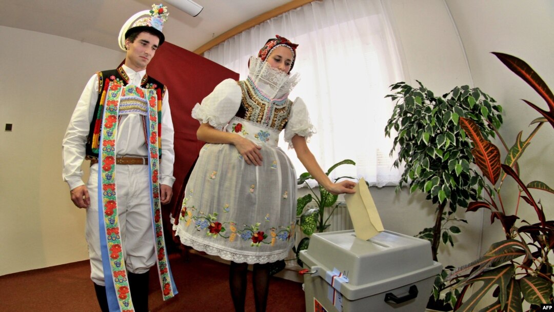 People wearing traditional costumes cast their votes at a polling station in Strazovice, in south Moravia.