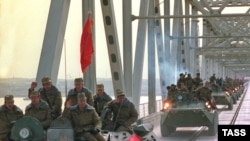 FILE: A column of Soviet military vehicles crosses the border in Termez, Uzbekistan as they return from Afghanistan (February 1989).