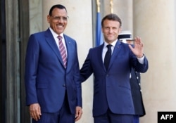Президент Франции Эммануэль Макрон и свергнутый президент Нигера Мохамед Базум в Елисейском дворце во время саммита по обсуждению нового глобального финансового пакта в Париже. 23 июня 2023 года