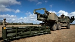 Soldiers prepare to load an Army Tactical Missile System (ATACMS) onto a High Mobility Artillery Rocket System (HIMARS)