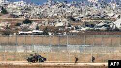 Израелски војници одат кон оклопно возило долж граничната ограда во Појасот Газа, во јужен Израел, на 30 септември 2025 