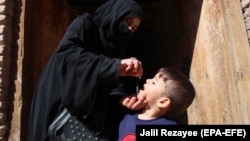 آرشیف - یک کارکن صحی یک کودک را در هرات واکسین پولیو می‌کند. March 31, 2021