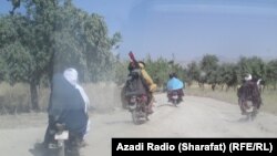 Мотоциклмен кетіп бара жатқан Талибан әскері. Көрнекі сурет.