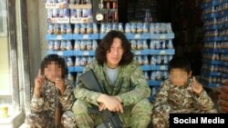 Kazakh IS militant Artyom Avdeyev poses with what he says are two Kyrgyz boys in an image he later deleted from his account.