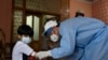 A health worker takes blood sample of a boy during door-to-door testing and screening for the coronavirus in the capital, Islamabad on June 10.