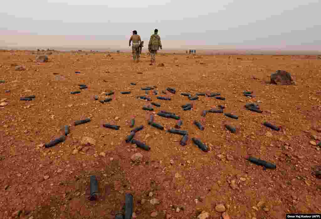 Syrian rebel fighters battle government forces near the village of Arafa, east of the city of Hama, in the central Hama Province. (AFP/Omar Haj Kadour)