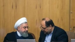President Hassan Rouhani (left) is speaking with minister of industry, Mohammad Shariatmadari, in the cabinet session, June 27, 2018.