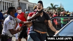 Un este bărbat arestat de poliție în urma protestelor împotriva guvernului președintelui Miguel Diaz-Canel în Havana, Cuba. Mii de oameni au participat la protestele care au început duminică. 