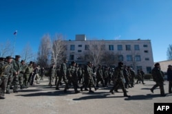 Украинские военные оставляют часть в Новофедоровке после штурма пророссийскими протестующими, 22 марта 2014 года