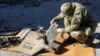 A Ukrainian police officer inspects parts of an unmanned aerial vehicle that authorities in Kyiv consider to be an Iranian-made suicide drone in Kharkiv on October 6.