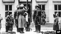 Німецькі та російські офіцери вітають прапор з нацистською свастикою під час параду в Бресті-Литовську після вторгнення в Польщу після. Брест-Литовськ, 22 вересня 1939 року