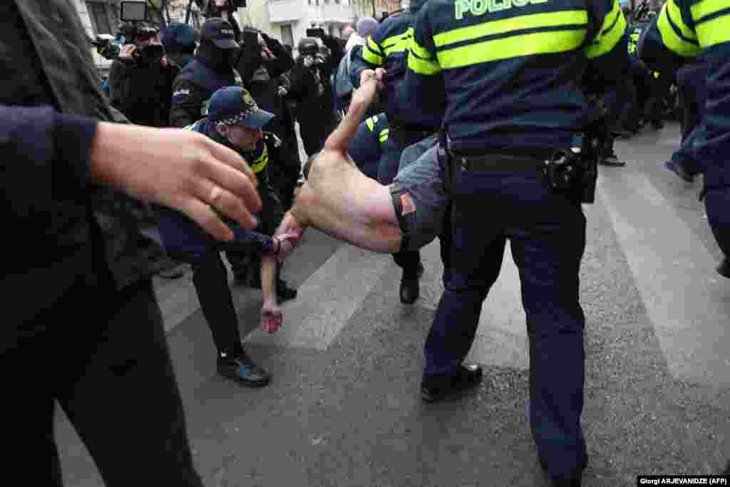 Georgian police detain a demonstrator during a protest against the published results of last month&#39;s parliamentary elections in Tbilisi on November 19.