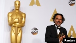 "Birdman" director Alejandro Inarritu poses with the Oscars for best director, best original screenplay, and best picture.