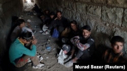 Afghan migrants hide from security forces in a tunnel under train tracks after crossing illegally into Turkey from Iran on August 23, 2021 -- days after the Taliban seized power in Afghanistan. 