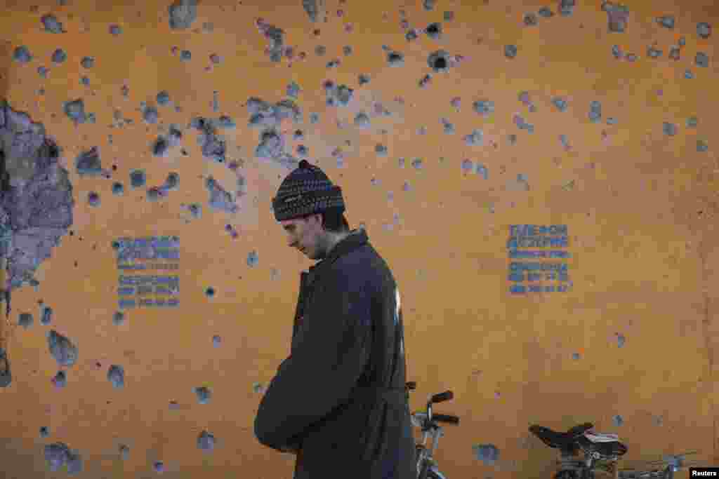 A man stands with a queue of people waiting for relief packages given out by the International Committee of the Red Cross in the eastern Ukrainian town of Debaltseve on February 23. (Reuters/​Baz Ratner)