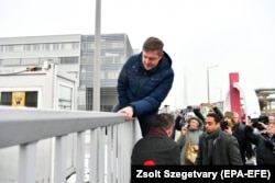Tóth Bertalan, az MSZP pártelnöke mászik át a közmédia telephelyének kerítésén 2017 decemberében egy tüntetés során