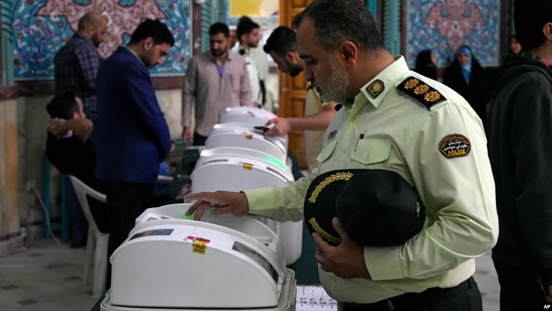 An Iranian police colonel votes in Iranian parliamentary elections that were reportedly marred by low turnout.